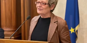 Annamaria Furlan parla da un podio con bandiere italiana ed europea.