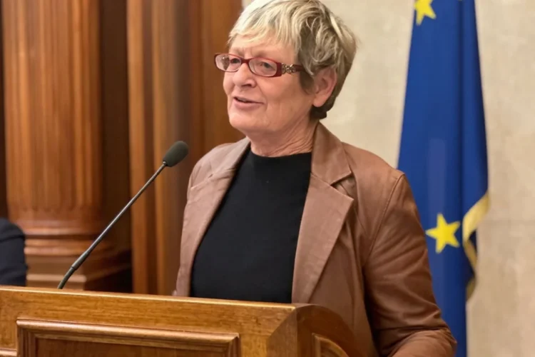 Annamaria Furlan parla da un podio con bandiere italiana ed europea.