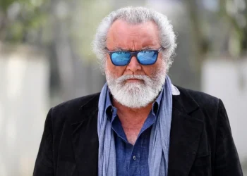 Diego Abatantuono con occhiali da sole blu e barba grigia folta.