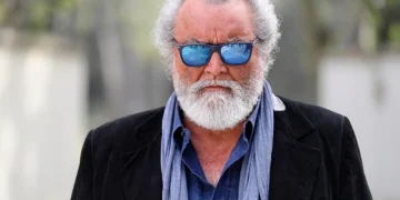 Diego Abatantuono con occhiali da sole blu e barba grigia folta.