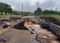 Strada distrutta dall'alluvione con acqua fangosa che scorre, detriti e escavatore. Uragano Lala alle Hawaii tra piogge torrenziali e blackout: oltre 200mila famiglie senza corrente