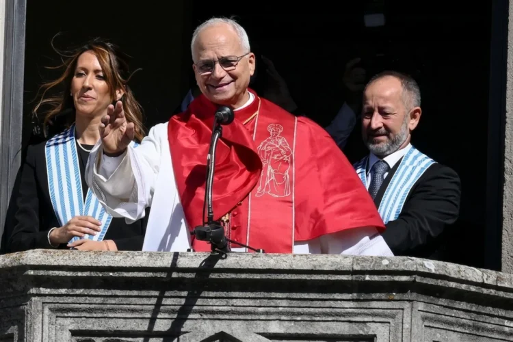 Cardinale sorridente saluta da balcone con collaboratori a San Marino