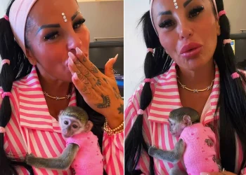 Rita De Crescenzo tiene in braccio piccola scimmia vestita di rosa