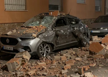 Auto grigia danneggiata da macerie dopo un terremoto a Granada