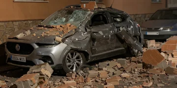 Auto grigia danneggiata da macerie dopo un terremoto a Granada