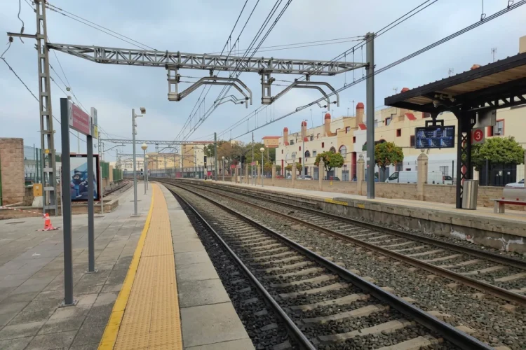 Binari del treno vuoti in stazione con banchina gialla.