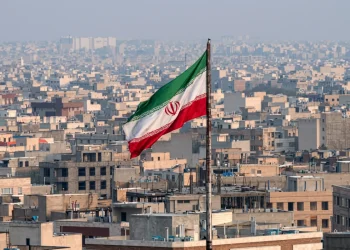 Bandiera dell'Iran sventola sopra i tetti della capitale Teheran