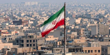 Bandiera dell'Iran sventola sopra i tetti della capitale Teheran