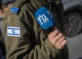 Soldato israeliano con bandiera e microfono di Galei Tzahal (Army Radio)