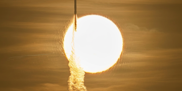 Razzo si lancia con scia luminosa davanti a un corpo celeste brillante. Il telescopio spaziale Roman lanciato da Cape Canaveral: parte la missione su materia ed energia oscura