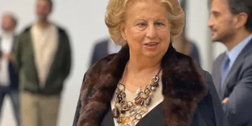 Maria Falcone sorride, indossa una collana e una pelliccia marrone.