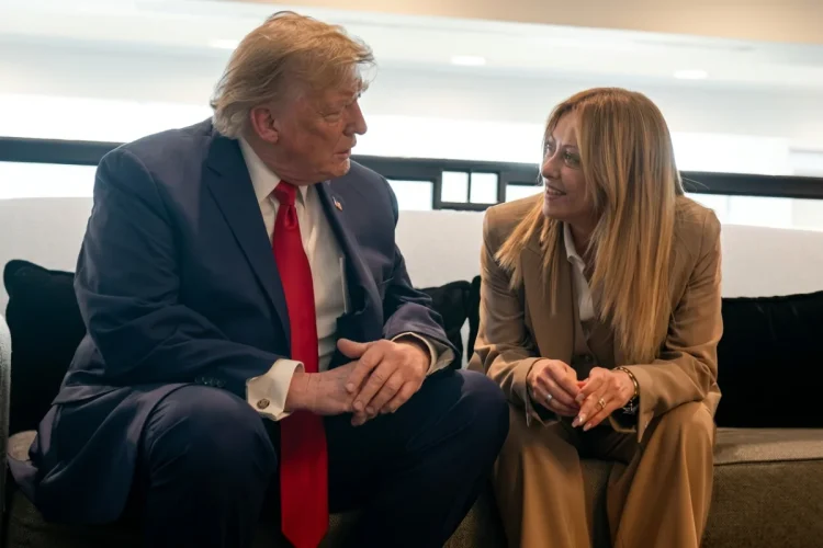 Donald Trump e Giorgia Meloni siedono sorridendo, conversano animatamente sul divano.