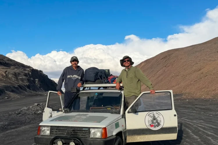 Due uomini sorridono con Fiat Panda 4x4 nel deserto montano