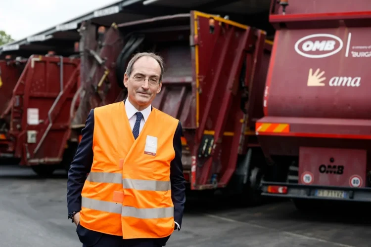 Alessandro Filippi in gilet arancione posa davanti camion Ama