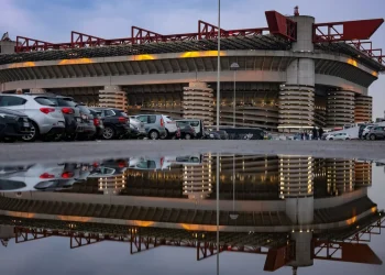Esterno dello Stadio San Siro di Milano con riflesso in una pozzanghera.