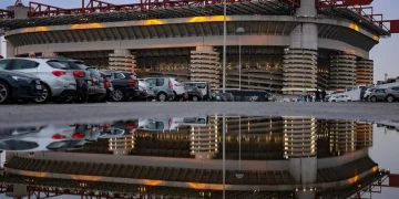 Esterno dello Stadio San Siro di Milano con riflesso in una pozzanghera.