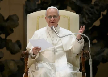Papa Francesco sorride mentre parla durante un discorso ufficiale.