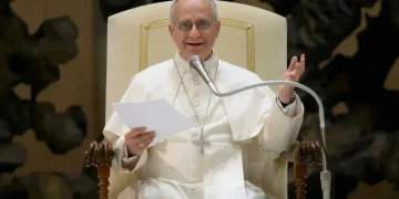 Papa Francesco sorride mentre parla durante un discorso ufficiale.