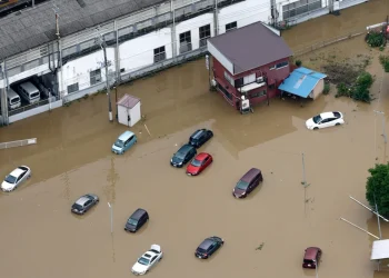 Vista aerea di case e automobili sommerse dall'acqua alluvionale in Giappone.