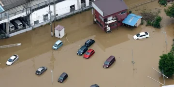 Vista aerea di case e automobili sommerse dall'acqua alluvionale in Giappone.
