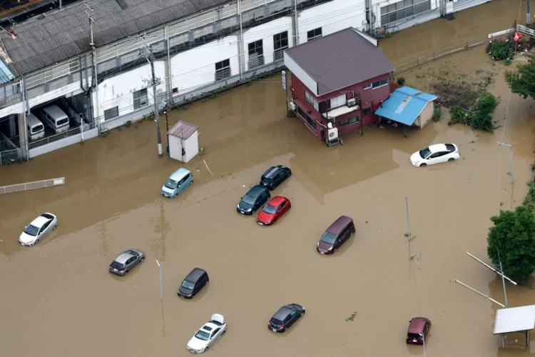 Vista aerea di case e automobili sommerse dall'acqua alluvionale in Giappone.