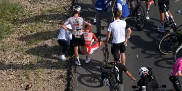 Ciclista Tadej Pogačar seduto a terra dopo caduta alla Vuelta.