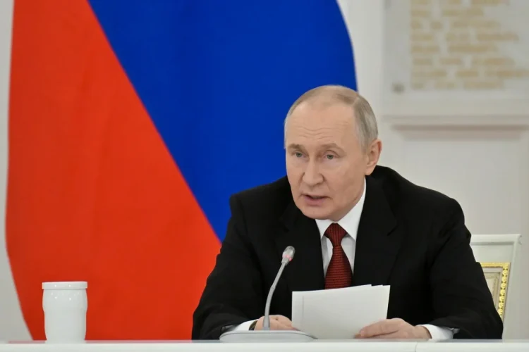 Vladimir Putin in giacca e cravatta parla al microfono