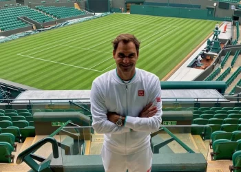 Roger Federer sorride sul campo centrale di Wimbledon vuoto