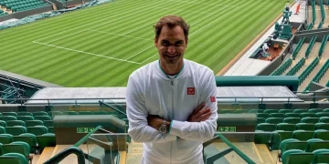 Roger Federer sorride sul campo centrale di Wimbledon vuoto