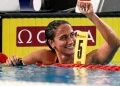 Nuotatrice Simona Quadarella sorride trionfante, celebra vittoria in piscina.