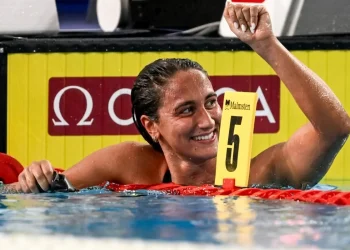 Nuotatrice Simona Quadarella sorride trionfante, celebra vittoria in piscina.