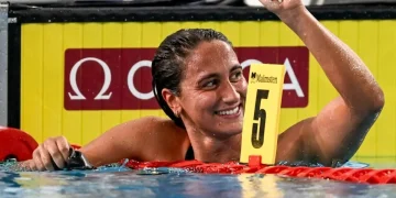 Nuotatrice Simona Quadarella sorride trionfante, celebra vittoria in piscina.