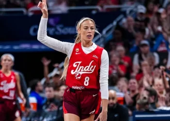 Giocatrice WNBA con maglia numero 8 e due dita alzate in campo.