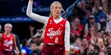 Giocatrice WNBA con maglia numero 8 e due dita alzate in campo.