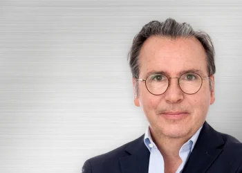 Ritratto di Carlos Tavares, CEO di Stellantis, sorride con occhiali.