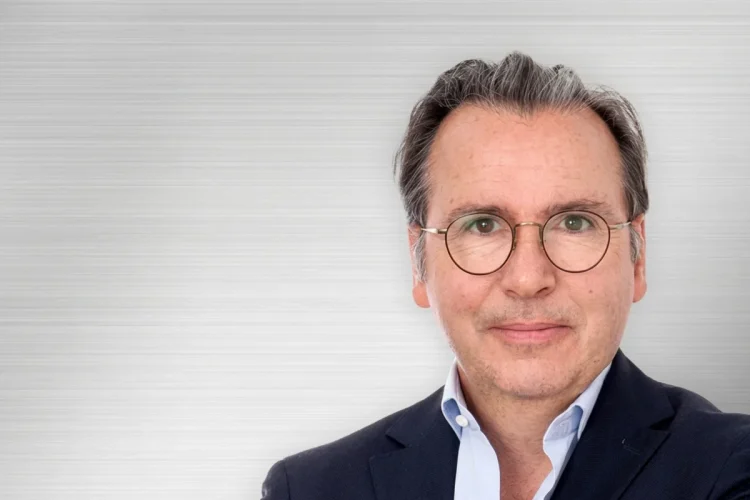 Ritratto di Carlos Tavares, CEO di Stellantis, sorride con occhiali.
