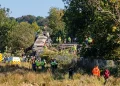 Treno passeggeri deragliato con soccorritori e ambulanza in zona boschiva