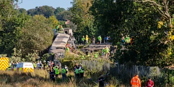 Treno passeggeri deragliato con soccorritori e ambulanza in zona boschiva