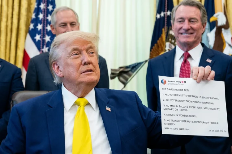 Donald Trump con giacca blu e cravatta gialla in un ufficio.