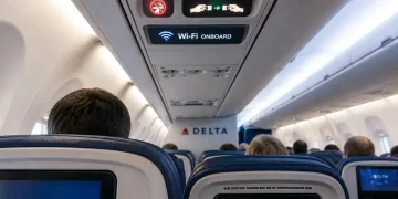 Interno aereo Delta, logo Wi-Fi acceso, schermi posti passeggeri.