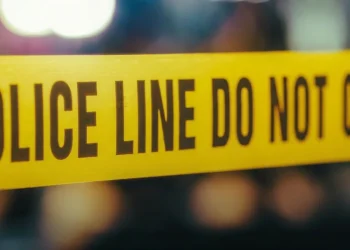 Nastro giallo "POLICE LINE DO NOT CROSS" su scena del crimine