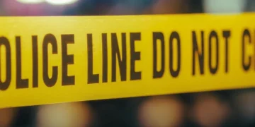 Nastro giallo "POLICE LINE DO NOT CROSS" su scena del crimine