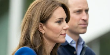 Kate Middleton di profilo con il Principe William, entrambi guardano avanti.