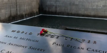 Rose rosse sul nome inciso World Trade Center al memoriale 11 settembre.