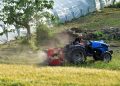 A man driving a tractor in a field near Rizza, Veneto, Italy.