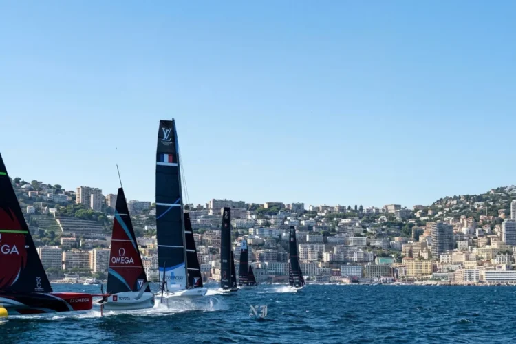 Barche a vela America's Cup sfrecciano in mare davanti alla costa di Napoli.