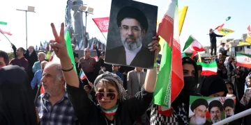 An Iranian woman holds a picture of Ayatollah Mojtaba Khamenei
