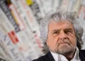 Beppe Grillo con capelli e barba grigi guarda in alto.