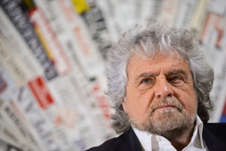 Beppe Grillo con capelli e barba grigi guarda in alto.