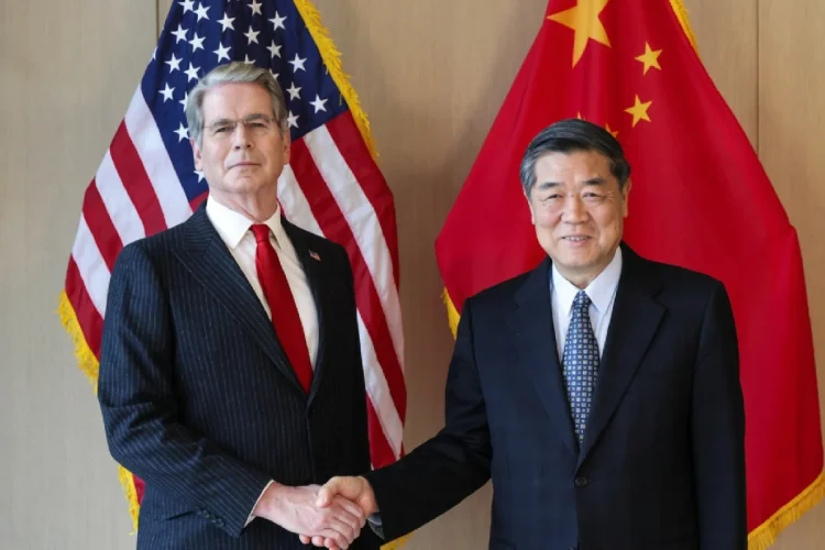 Due politici si stringono la mano davanti alle bandiere di USA e Cina.